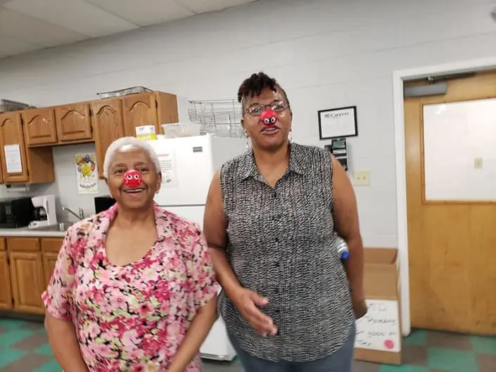 Two women wearing red noses.