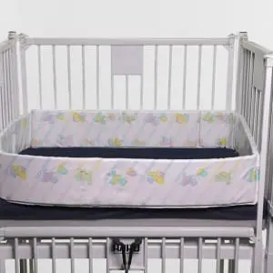 Crib Side Rail Pad fitted on a mattress in a crib frame