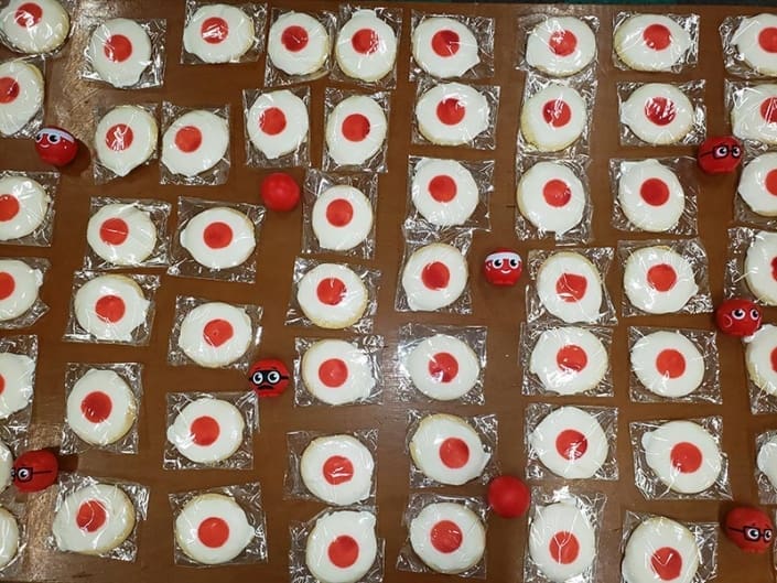 Cookies with white icing, and red icing in the middle to look like a red nose.