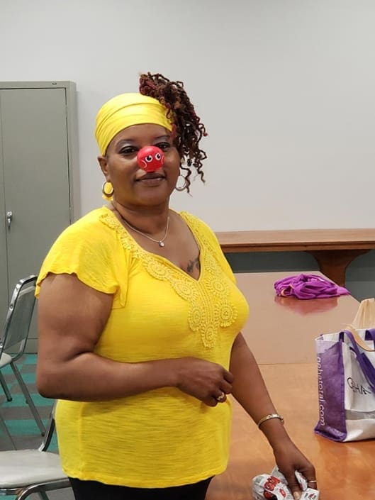 A woman wearing a red nose.