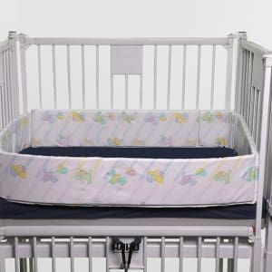 Crib Side Rail Pad fitted on a mattress in a crib frame